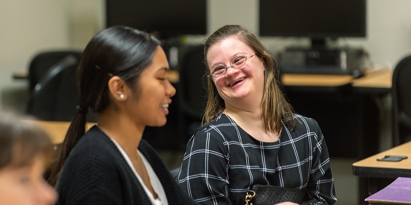 2 students smiling at each other